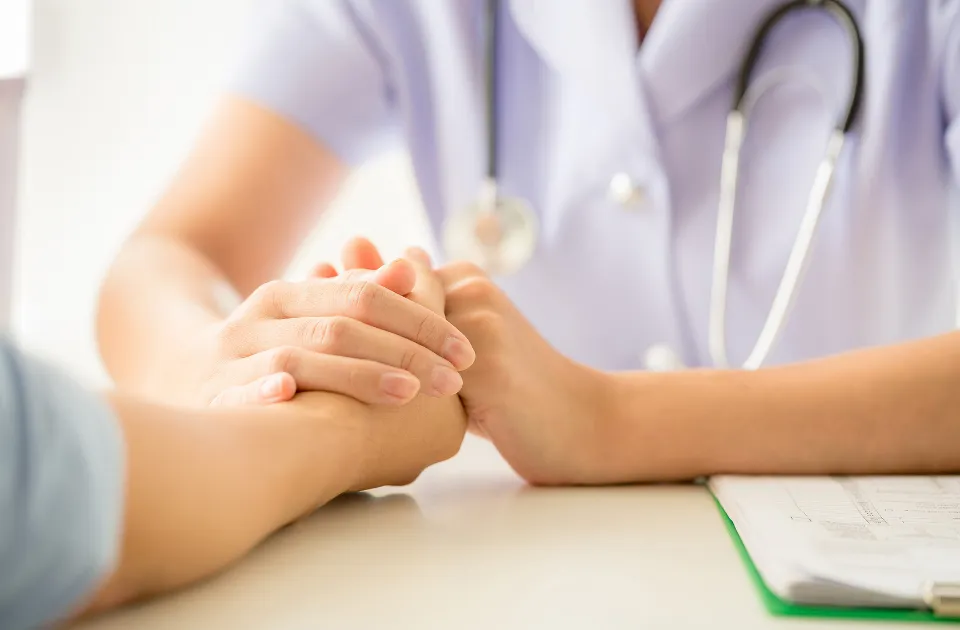 Especialista en salud metal sosteniendo la mano del paciente